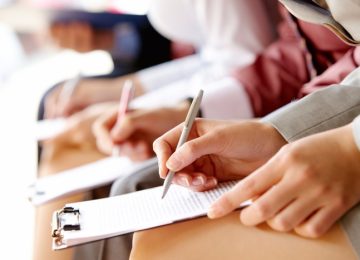 Businesspeople hands over papers making notes at seminar